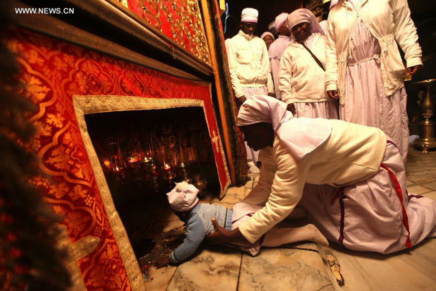 Nigerian pilgrims pray inside the Grotto in the Church of the Nativity, traditionally believed to be the birthplace of Jesus Christ, as preparations for Christmas celebrations in the West Bank biblical town of Bethlehem on Dec. 24, 2012. (Xinhua/Fadi Arouri)
