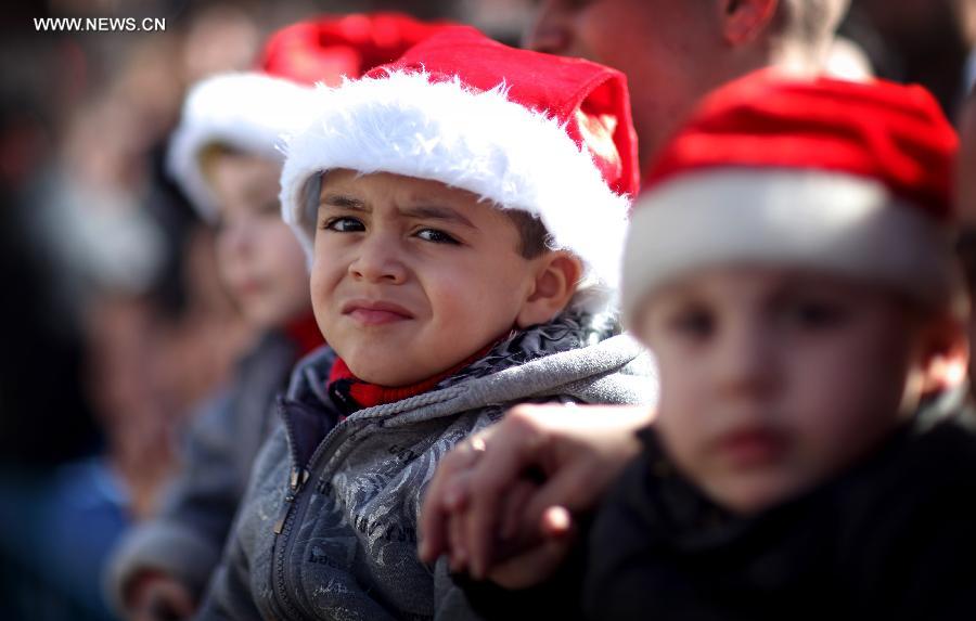 Children wearing Santa hats are seen at the Church of the Nativity, traditionally believed to be the birthplace of Jesus Christ, as they attend the Christmas celebrations in the West Bank biblical town of Bethlehem on Dec. 24, 2012. (Xinhua/Fadi Arouri)
