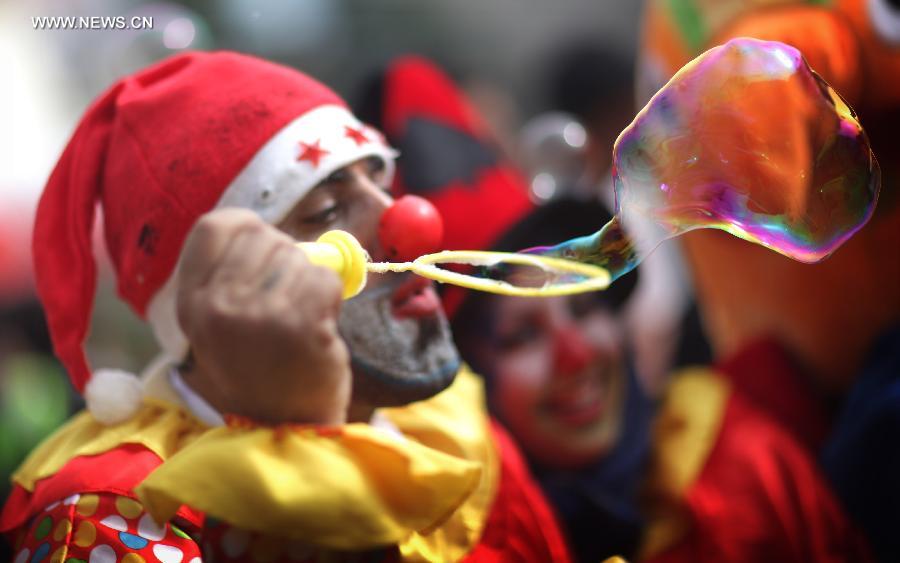 A clown blows a bubble the Church of the Nativity, traditionally believed to be the birthplace of Jesus Christ, as he attends the Christmas celebrations in the West Bank biblical town of Bethlehem on Dec. 24, 2012. (Xinhua/Fadi Arouri)