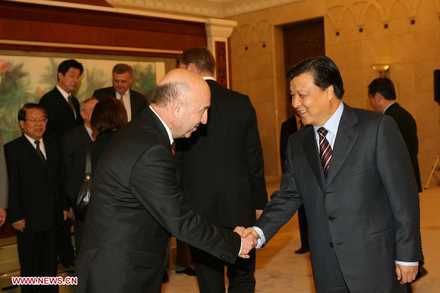 In this file photo taken on May 11, 2006, Liu Yunshan (R), then a member of the Political Bureau of the Communist Party of China (CPC) Central Committee, also a member of the Secretariat of the CPC Central Committee and head of the Publicity Department of the CPC Central Committee, shakes hands with a Russian guest while meeting a delegation of Russian mainstream media heads at the Great Hall of the People in Beijing, capital of China. (Xinhua/Liu Weibing) 