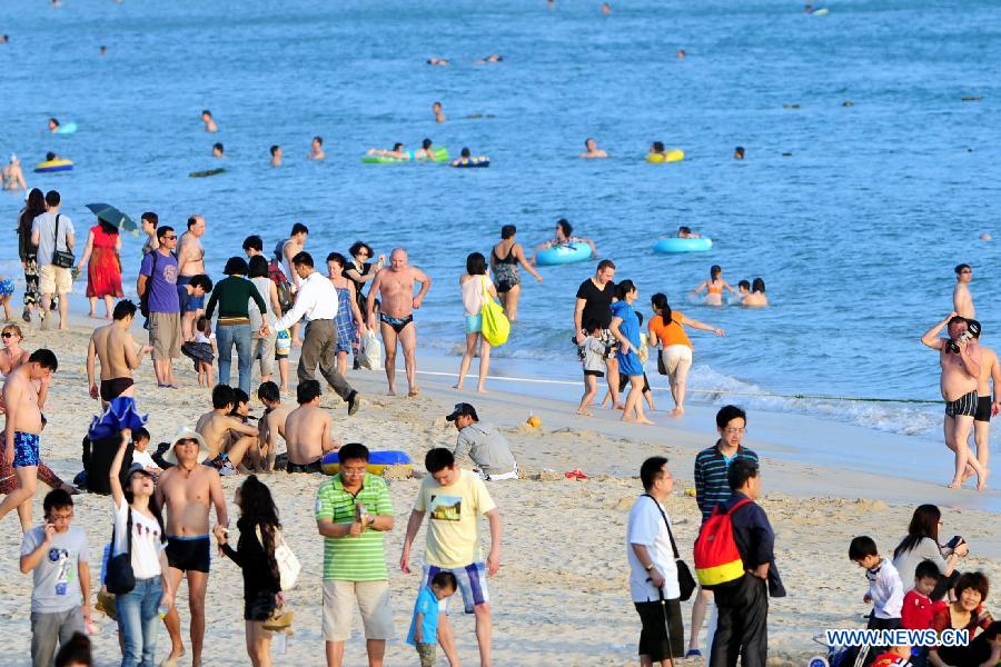 Tourists relax at a beach in Sanya, a famous tourism city in south China's Hainan Province, Dec. 25, 2012. Many tourists chose to visit Sanya for its warm weather. (Xinhua/Hou Jiansen) 