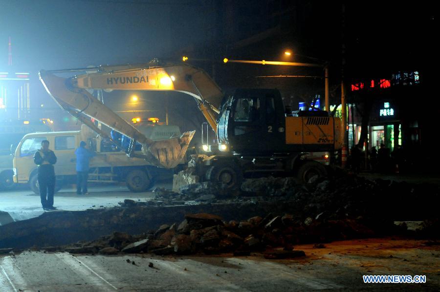 An excavator is used to repair the collapsed section of a road intersection in Taiyuan, capital of north China' Shanxi Province, Dec. 26, 2012. The road cave-in happened Wednesday afternnon, leaving a pit measuring around 3 to 4 meters deep, 15 meters long, and 5 meters wide. No casualties were reported. (Xinhua/Fan Minda) 