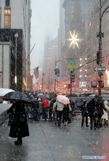 People walk in a winter storm as snow falls in Manhattan, New York City, on Dec. 26, 2012. The strong storm system that hit the central and southern U.S. on Christmas Day moved to the eastern U.S. on Wednesday, causing flight delays and dangerous road conditions in the Northeast. (Xinhua/Wang Lei) 