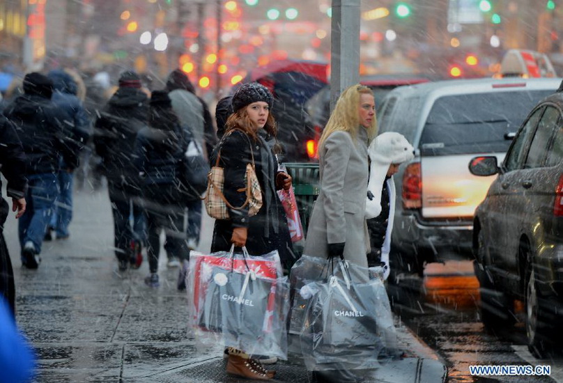 People walk in a winter storm as snow falls in Manhattan, New York City, on Dec. 26, 2012. The strong storm system that hit the central and southern U.S. on Christmas Day moved to the eastern U.S. on Wednesday, causing flight delays and dangerous road conditions in the Northeast. (Xinhua/Wang Lei) 