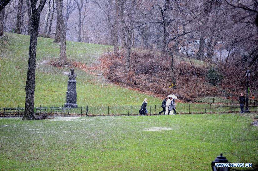 People walk in a winter storm as snow falls at the Central Park in New York City on Dec. 26, 2012. The strong storm system that hit the central and southern U.S. on Christmas Day moved to the eastern U.S. on Wednesday, causing flight delays and dangerous road conditions in the Northeast. (Xinhua/Wang Lei)