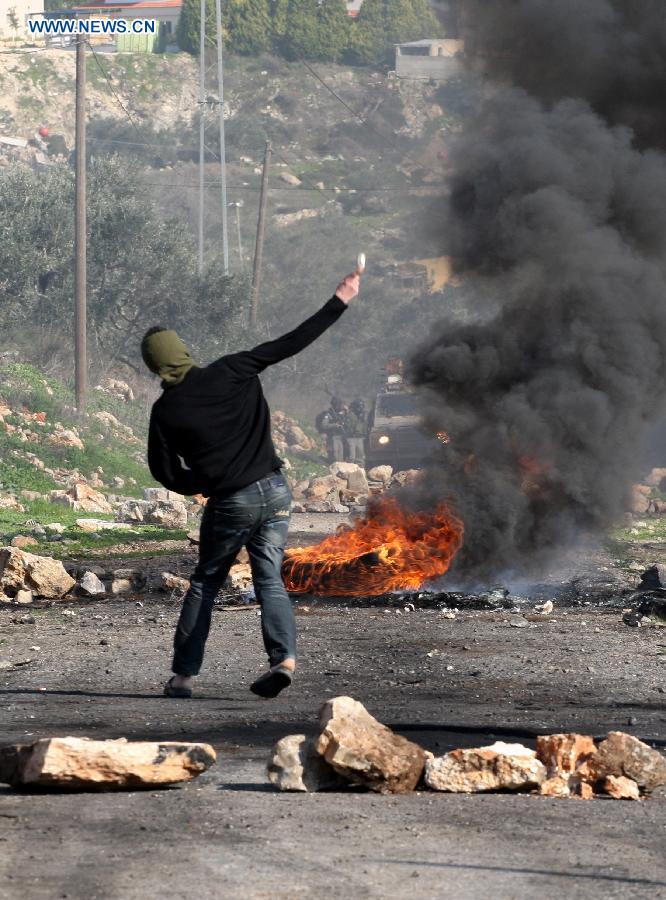 A Palestinian protester throws stones at Israeli soldiers during a protest against the expanding of Jewish settlement in Kufr Qadoom village near the West Bank city of Nablus, on Dec. 28, 2012. (Xinhua/Nidal Eshtayeh) 
