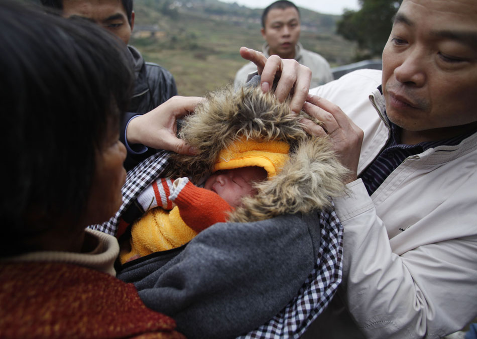 A baby is rescued by police from a child trafficking ring in Quanzhou, Fujian province on Dec. 19, 2012. 89 children rescued in the latest crackdown on child trafficking have been sent to local civil affairs departments for temporary placement and the police are searching for their natural parents.  (Xinhua/Wang Shen)