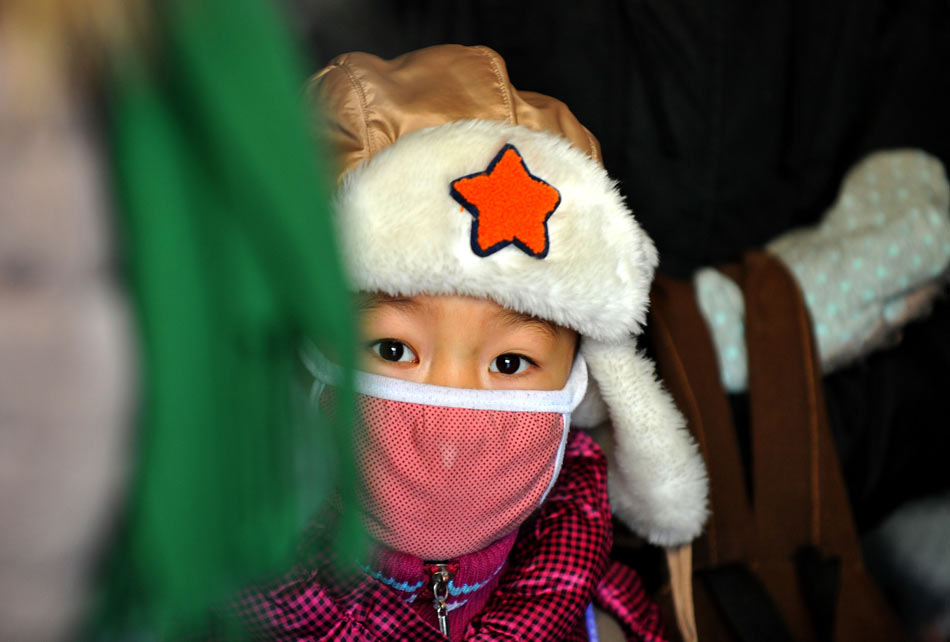A primary school student from West Ujimqin Banner of Inner Mongolia waits for the bus to take him home. More than 2,400 children of primary and junior high schools from the West Ujimqin Banner began to take winter break on Dec. 23, 2012. The continuous snows since November caused difficulties for the children living in remote pastoral areas to go home. The local governments organized 18 minibuses, more than 100 off-road vehicles and several snow vehicles to send 93 local students home. (Xinhua/Ren Junchuan)