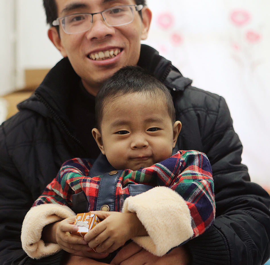 Fanfan (pseudonym) enjoys the chocolates given by the doctor with smile on Dec. 24, 2012.China’s first case of father and son across blood type liver transplant succeeded in Beijing Armed Police General Hospital on Nov. 20, 2012. A month later, Wan Jinqiang and his son Fanfan were discharged from the hospital on Dec. 24, 2012.(Xinhua/Wan Xiang)