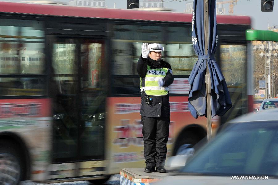 A policewoman directs the traffic at an intersection in Yinchuan City, capital of northwest China's Ningxia Hui Autonomous Region, Jan. 1, 2013. The revised traffic regulation takes effect on Tuesday. According the new rules, 52 different sorts of violations can result in deducting points for punishment, up from 38 under the previous regulation. (Xinhua/Peng Zhaozhi)
