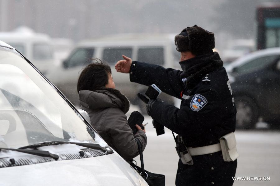 A policeman stops a driver violating traffic rules in Changchun, capital of northeast China's Jilin Province, Jan. 1, 2013. The revised traffic regulation takes effect on Tuesday. According the new rules, 52 different sorts of violations can result in deducting points for punishment, up from 38 under the previous regulation. (Xinhua/Lin Hong) 