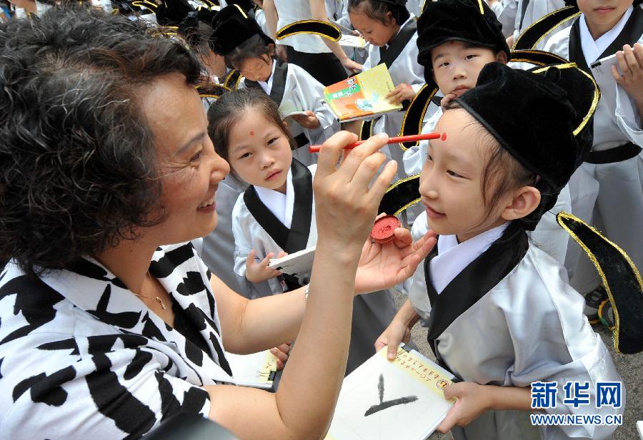 Growth is achieved by new start: Students in traditional costume are seen in an opening ceremony of new term in vintage style held in Nanjing’s Confucius Temple Elementary School, Sept. 1, 2012. (Xinhua/Sun Sen)