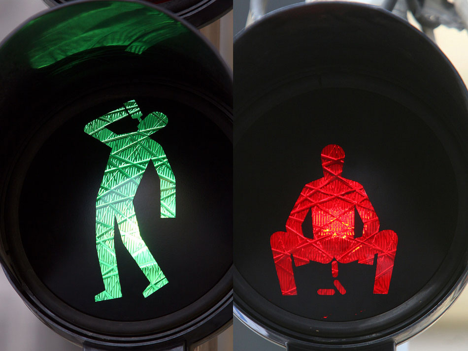 Altered traffic signs with red and green men appearing to lie down, drink and defecate appearin Prague in April 2012. The signs were deemed illegal and were removed by the authorities, Guerrilla art group Ztohoven claimed responsibility. (Photo/ ImagineChina)