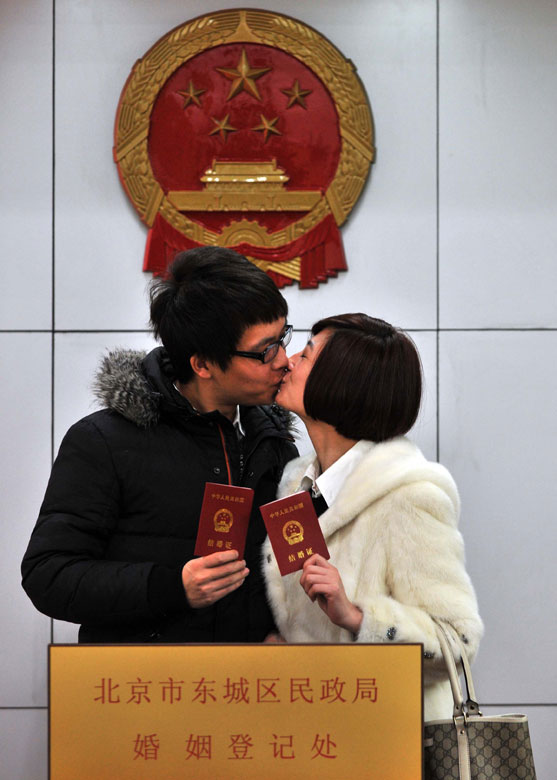 A couple kiss each other after they finish the marriage registration in Dongcheng District, Beijing, Jan. 4, 2013. Quite a number of couples flocked to tie the knot on Jan. 4, 2013, or 2013/1/4, which sounds like "love you forever" in Chinese. (Xinhua/Li Wen)