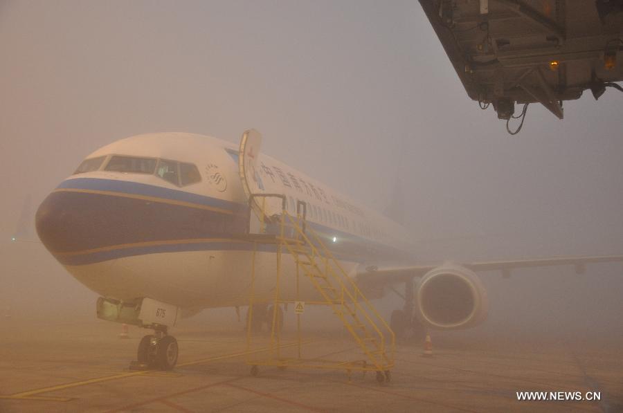 An airliner is grounded at Chengdu Shuangliu International Airport due to heavy fog in Chengdu, capital of southwest China's Sichuan Province, Jan. 6, 2013. Heavy fog here forced the airport to shut down on Jan. 6, grounding more than 100 flights and stranding nearly 10,000 passengers. By 11:30 a.m., the fog had begun to disperse and three Air China flights were allowed to take off from the airport. (Xinhua/Lu Junming) 