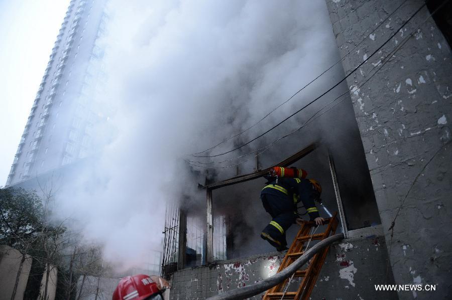 A firefighter gets into a residential building on fire on the Honggu Road in Nanchang, capital of east China's Jiangxi Province, Jan. 6, 2013. A fire broke out on the first floor of the building on Sunday. No casualty is reported at present and the cause is still under investigation. (Xinhua/Zhou Mi) 