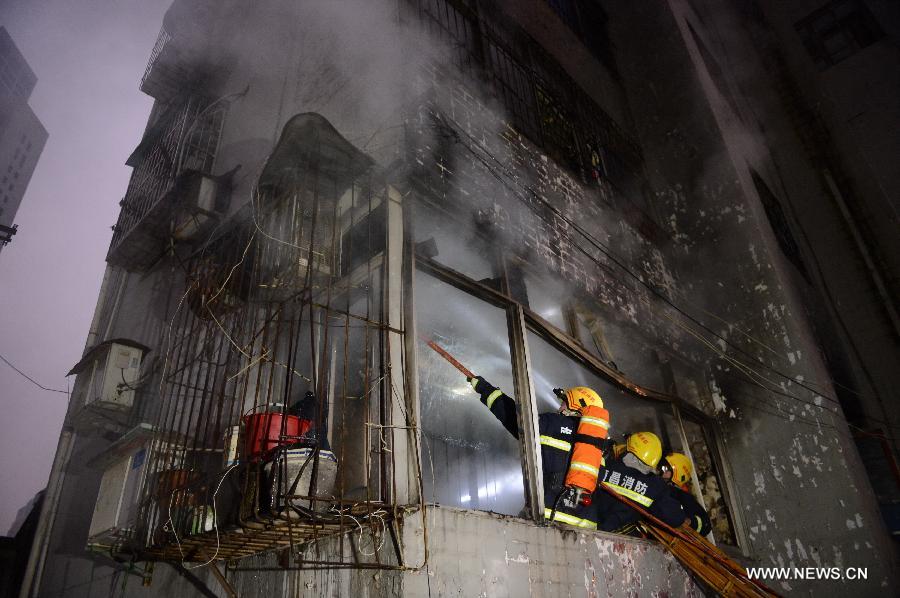 Firefighters extinguish fire at a residential building on the Honggu Road in Nanchang, capital of east China's Jiangxi Province, Jan. 6, 2013. A fire broke out on the first floor of the building on Sunday. No casualty is reported at present and the cause is still under investigation. (Xinhua/Zhou Mi)  