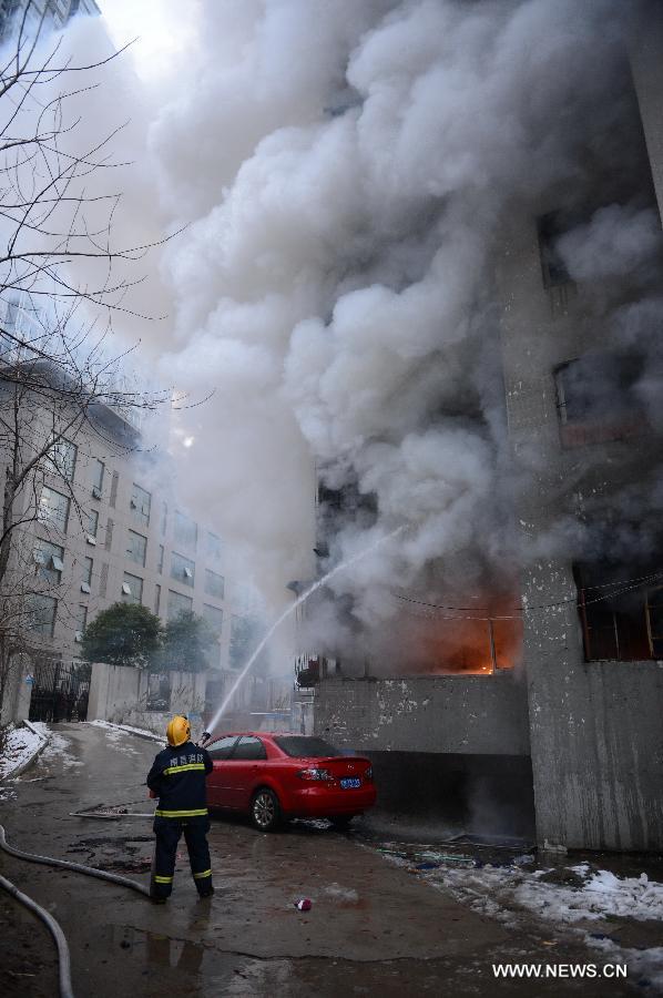 A firefighter extinguishes fire at a residential building on the Honggu Road in Nanchang, capital of east China's Jiangxi Province, Jan. 6, 2013. A fire broke out on the first floor of the building on Sunday. No casualty is reported at present and the cause is still under investigation. (Xinhua/Zhou Mi)  