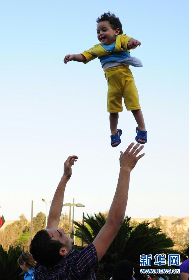 A man plays with the little boy in Al-Azhar Park in Cairo, Egypt, April 16, 2012. The day was Egyptian traditional festival of wind which celebrates spring’s coming. (Xinhua/Qin Haishi)