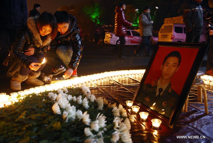 Citizens light the candles during a memorial service for the three firefighters who died while putting out fire in a factory blaze, at the Wushan Square in Hangzhou, capital of east China's Zhejiang Province, Jan. 7, 2013. Local citizens gathered here on Monday evening to mourn the three firefighters who sacrificed their lives while putting out a fire in Hangzhou's Xiaoshan District, six days after the fire broke out. The three firefighters, Yin Jinliang, Chen Wei and Yin Zhihui, were ratified as martyrs and awarded gold medals for their dedication to the national defence. They were also personally awarded the top-grade merit citation. (Xinhua/Cui Xinyu) 