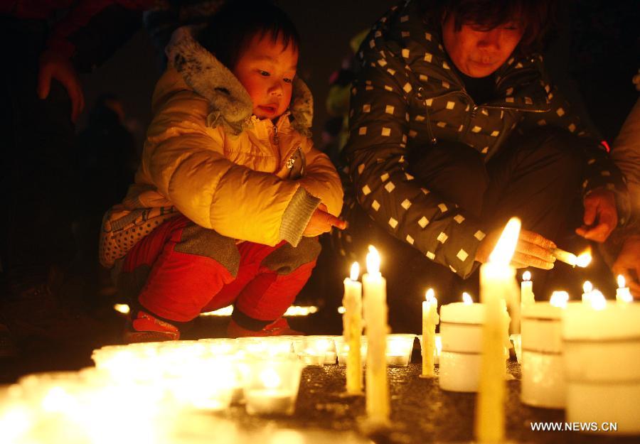 Citizens light the candles during a memorial service for the three firefighters who died while putting out fire in a factory blaze, at the Wushan Square in Hangzhou, capital of east China's Zhejiang Province, Jan. 7, 2013. Local citizens gathered here on Monday evening to mourn the three firefighters who sacrificed their lives while putting out a fire in Hangzhou's Xiaoshan District, six days after the fire broke out. The three firefighters, Yin Jinliang, Chen Wei and Yin Zhihui, were ratified as martyrs and awarded gold medals for their dedication to the national defence. They were also personally awarded the top-grade merit citation. (Xinhua/Cui Xinyu) 