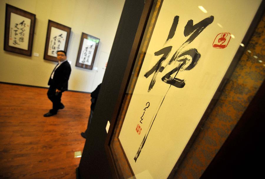 A visitor is seen at a tour exhibition of Venerable Master Hsing Yun's One-Stroke Calligraphy held at the Hainan Provincial Museum in Haikou, capital of south China's Hainan Province, Jan. 8, 2013. A total of 55 calligraphy works by master Hsing Yun were on display at the exhibition that will last until Jan. 20. (Xinhua/Guo Cheng) 