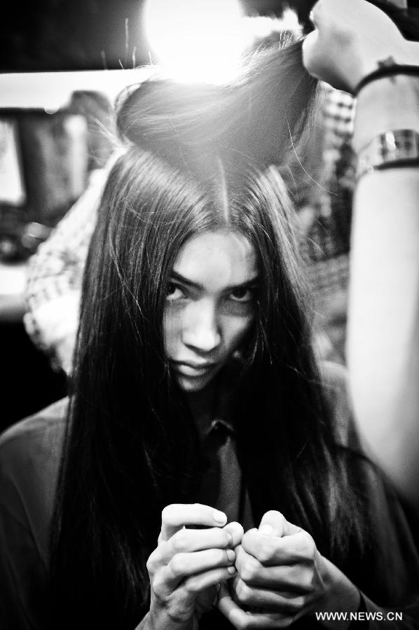 A model gets her hair prepared backstage during the Vivienne Tam Spring/Summer 2013 collection show at New York Fashion Week in New York, the United States, Sept. 12, 2012. (Xinhua/Shen Hong) 