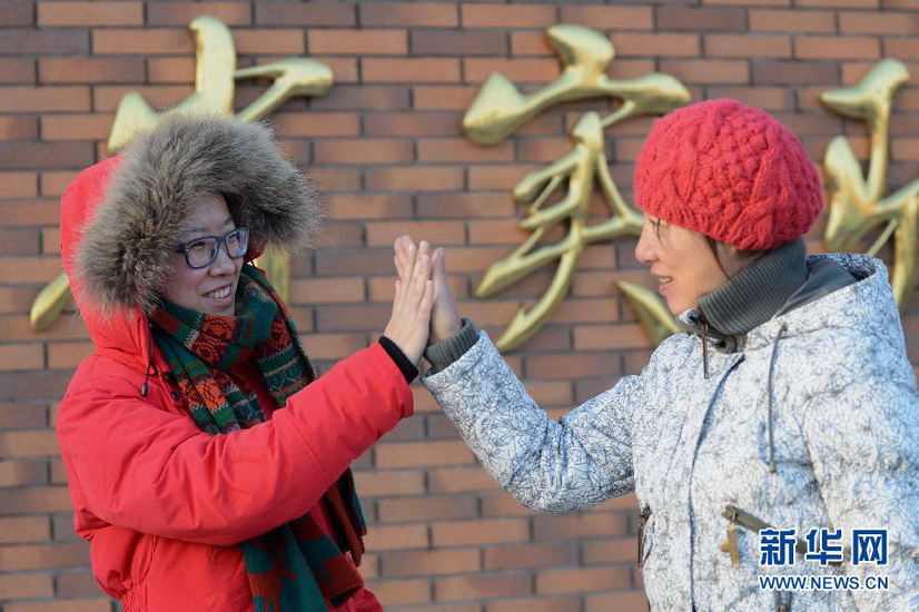 A mother wishes her daughter good luck for at an exam venue in Jilin province on Jan. 5, 2013. (Xinhua/Lin Hong)