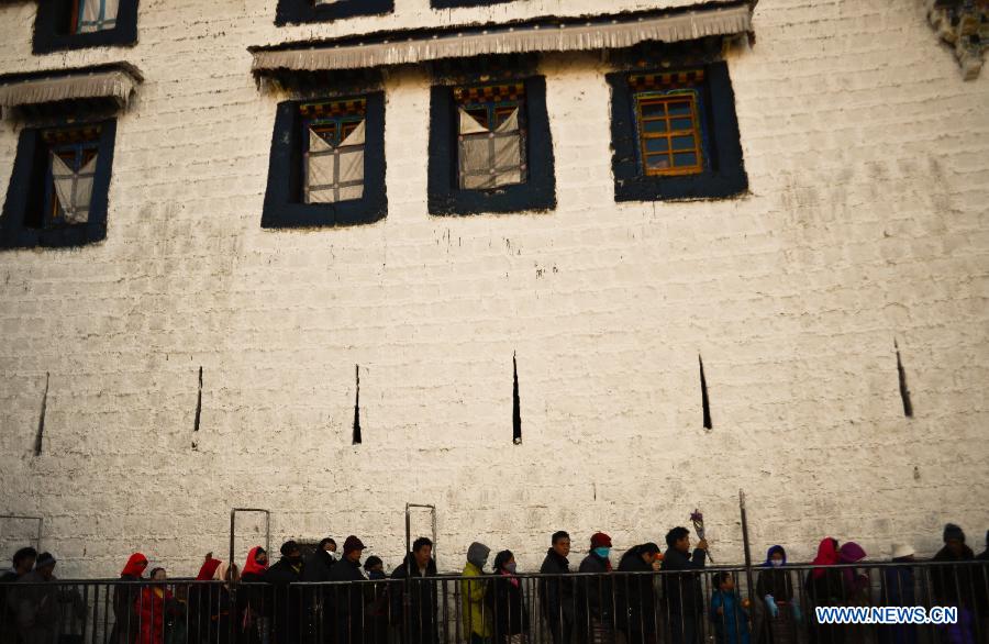 Buddhists wait in queue to pray in front of the Jokhang Temple, a center of pilgrimage, in Lhasa, capital of southwest China's Tibet Autonomous Region, Jan. 7, 2013. Many people flock to Lhasa to make a pilgrimage in winter, the slack farming season. (Xinhua/Purbu Zhaxi) 