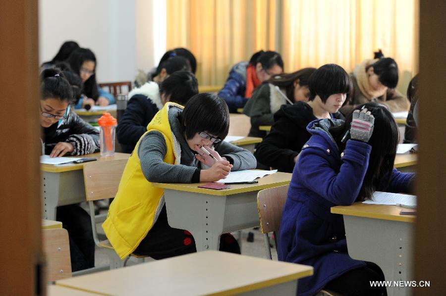 Students take a final exam in an examination room without invigilator at Hangzhou Normal University in Hangzhou, east China's Zhejiang Province, Jan. 9, 2013. Practising for almost two years, examinations without invigilator have been conducted in many departments and schools of the university, involving some 80 courses, which aim at making examinees feel being trusted and encouraging them to maintain honest. (Xinhua/Ju Huanzong)  
