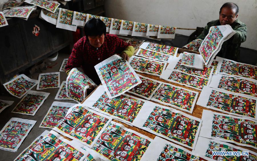 Craftsman Zhai Ruichen (R) and his wife Liu Shufang sort New Year pictures they paints in Liaocheng, east China's Shandong Province, Jan. 9, 2013. The couple were busy painting New Year pictures recently to meet the demand in local market for the Spring Festival in February. (Xinhua/Zhang Zhenxiang)