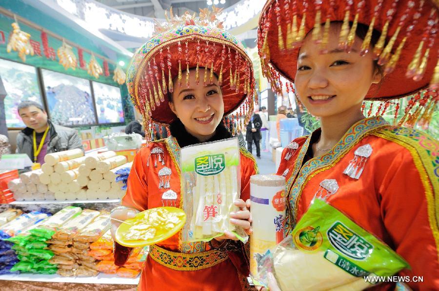 Saleswomen show products at the 12th Western China (Chongqing) International Agricultural Products Fair in southwest China's Chongqing, Jan. 10, 2013. The fair kicked off here on Thursday. (Xinhua/Li Jian) 