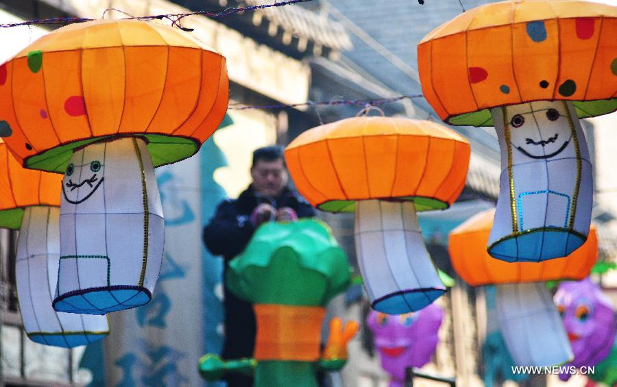 A worker displays lanterns to greet the upcoming Spring Festival, which falls on Feb. 10 this year, in Zhoucun, east China's Shandong Province, Jan. 12, 2013. (Xinhua/Dong Naide) 