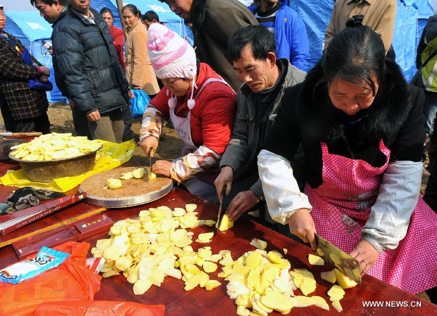 People from nearby villages cook for landslide-affected people at Gaopo Village in Zhenxiong County, southwest China's Yunnan Province, Jan. 12, 2013. Landslide-affected villagers in Gaopo Village have been temporarily settled in tents and got life necessities. Forty-six people were killed in the Friday landslide. Another two people were injured. (Xinhua/Chen Haining) 