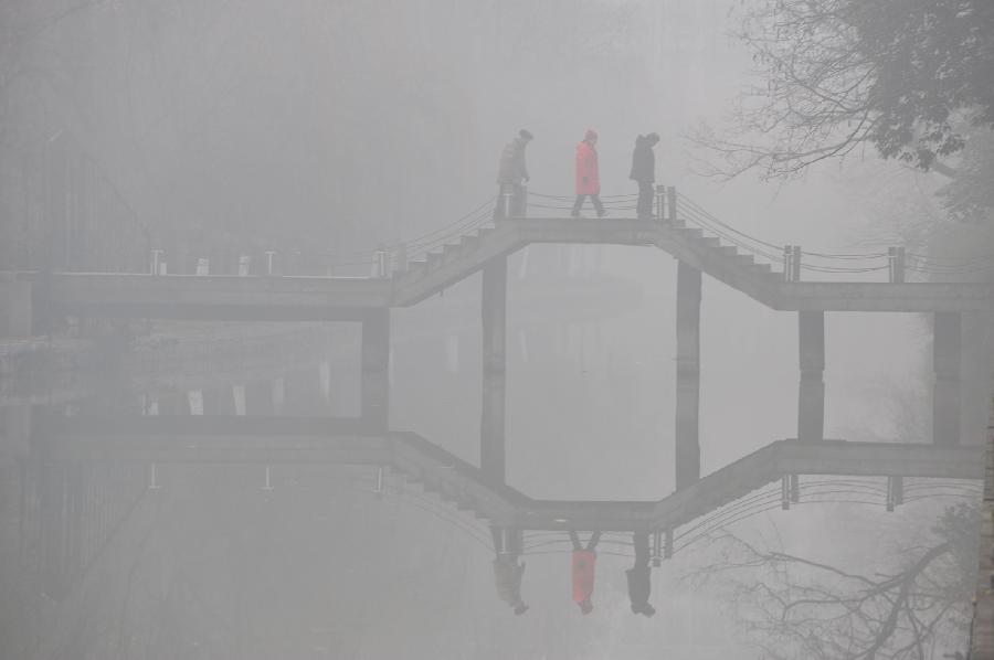 Citizens walk on a bridge in the fog in Hefei, capital of east China's Anhui Province, Jan. 13, 2013. Dense fog on Sunday hit China's east and central regions from the northeast to the south. (Xinhua/Yang Xiaoyuan) 