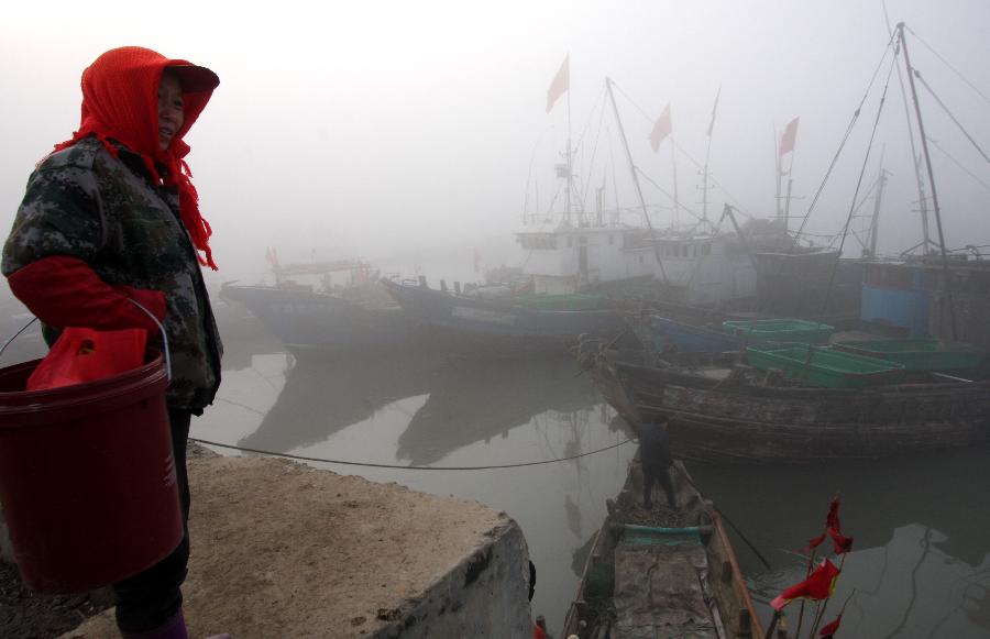Photo taken on Jan. 13, 2013 shows a fog-shrouded fishing port in Lianyungang City, east China's JIangsu Province. Dense fog on Sunday hit China's east and central regions from the northeast to the south, causing serious air pollution. (Xinhua/Geng Yuhe) 