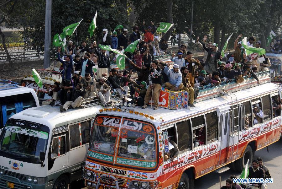 Supporters of Dr Tahir-ul-Qadri ride on vehicles during a long-march in eastern Pakistan's Lahore, Jan. 13, 2013. A Pakistani religious leader, Dr Tahir-ul-Qadri, started a long-march from Lahore to Islamabad to call for electoral reforms Sunday, local media reported. (Xinhua/Sajjad)  
