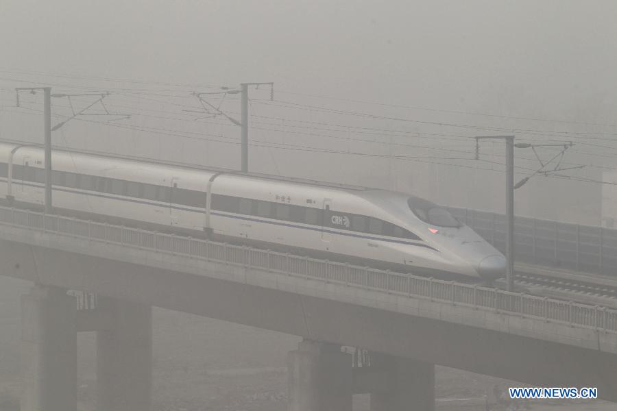 A high-speed railway runs amid heavy fog in Xuchang, central China's Henan Province, Jan. 14, 2013. Emergency response measures were adopted in many Chinese cities, where the air has held excessive levels of major pollutants in the past few days due to prolonged fog and smog. Heavy fog has caused highway closures and flight delays in several provinces. The elderly, children and those suffering from respiratory and cardiovascular diseases are advised to stay indoors to reduce exposure to polluted air. (Xinhua/Niu Shupei)