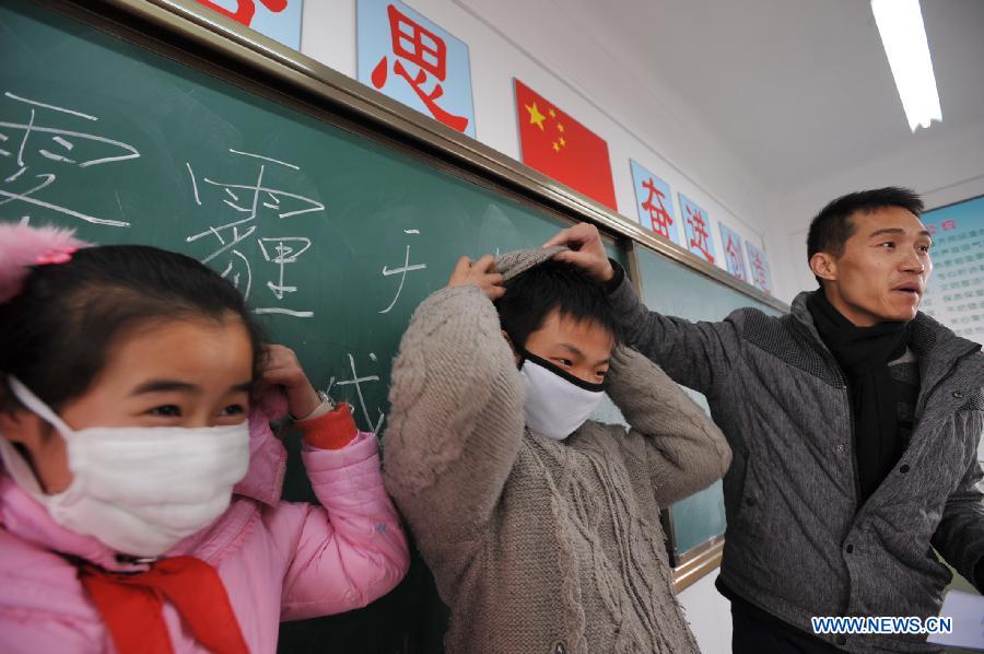 Two students demonstrate wearing masks under a guidance of a teacher in an indoor physical education class as the outdoor sports activities for primary and middle schools were ordered to be halted due to heavy air pollution in Hupo Shanzhuang Elementary School in Hefei, capital of east China's Anhui Province, Jan. 14, 2013. Emergency response measures were adopted in many Chinese cities, where the air has held excessive levels of major pollutants in the past few days due to prolonged fog and smog. Heavy fog has caused highway closures and flight delays in several provinces. The elderly, children and those suffering from respiratory and cardiovascular diseases are advised to stay indoors to reduce exposure to polluted air. (Xinhua/Yang Xiaoyuan) 