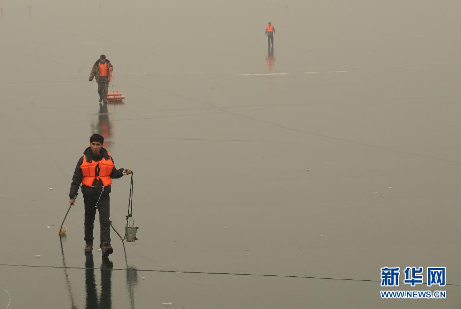 A water sampling staff walks on the ice of Yuecheng Reservoir on Jan. 7, 2013. (Xinhua/Zhu Xudong)