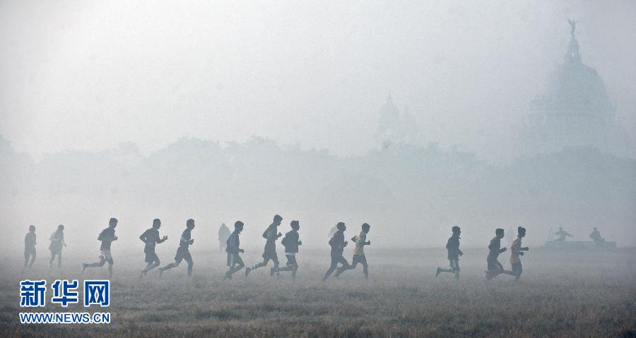Residents run in the fog at Maidan ground, a large region of greenery in Calcutta, capital of eastern Indian state West Bengal, Dec. 5, 2012. During the winter months, the northern areas of India often experience dense fog, causing traffic delays and disrupting air. (Photo/Xinhua)