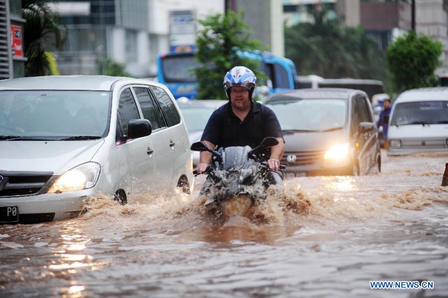 A motorcyclist wades through flood waters in Jakarta, Indonesia, Jan. 17, 2013. The Indonesian capital city of Jakarta was paralyzed by flood on Thursday following a massive downpour since Wednesday night, with its main roads inundated, public transport disrupted and operation of government offices and private sector coming to a standstill. (Xinhua/Veri Sanovri)