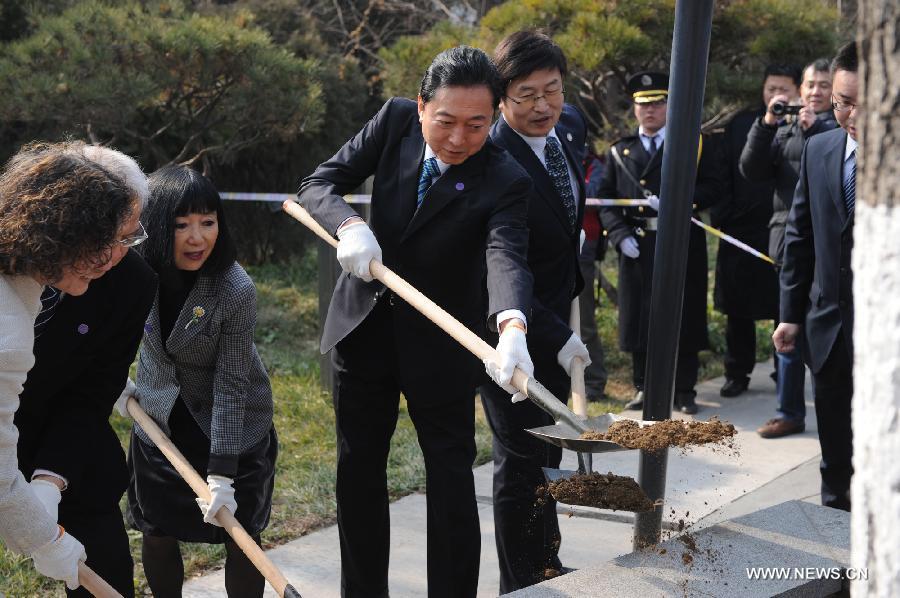 Former Japanese Prime Minister Yukio Hatoyama (4th L) and his wife (3rd L) plant a gingko when visiting the Memorial Hall of the Victims in Nanjing Massacre by Japanese Invaders in Nanjing, capital of east China's Jiangsu Province, Jan. 17, 2013. (Xinhua/Han Yuqing)