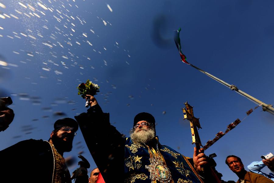 Bishop Vindictos, head of the Jordanian Orthodox Church, blesses worshippers during a mass at a baptism site by the Jordan River on Jan. 18, 2013. Thousands of Orthodox Christians flocked to the baptism site on Friday to start a pilgrimage. (Xinhua/Mohammad Abu Ghosh) 