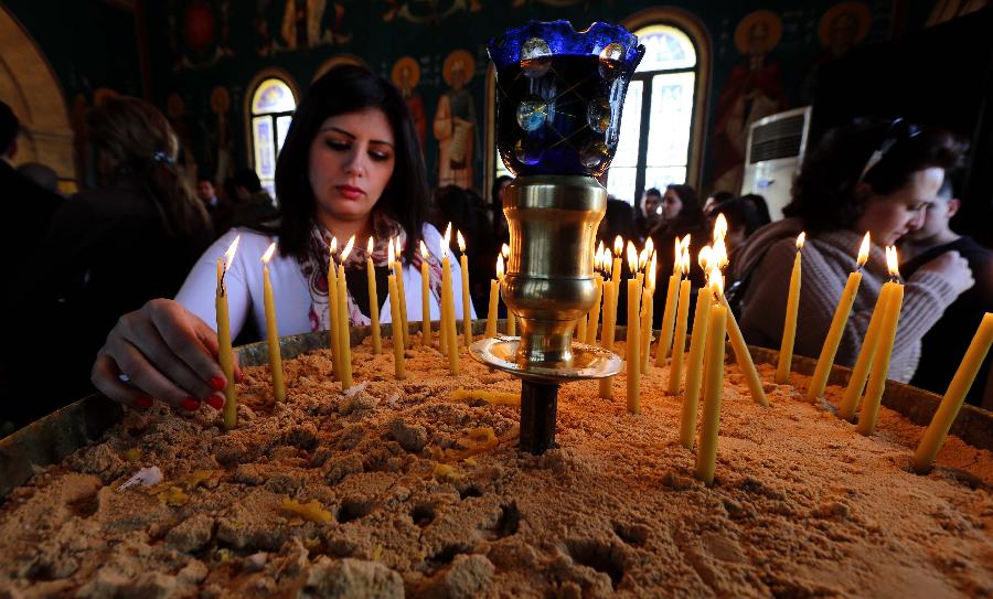 Orthodox Christian pilgrims light candles during a mass at a baptism site by the Jordan River on Jan. 18, 2013. Thousands of Orthodox Christians flocked to the baptism site on Friday to start a pilgrimage. (Xinhua/Mohammad Abu Ghosh) 