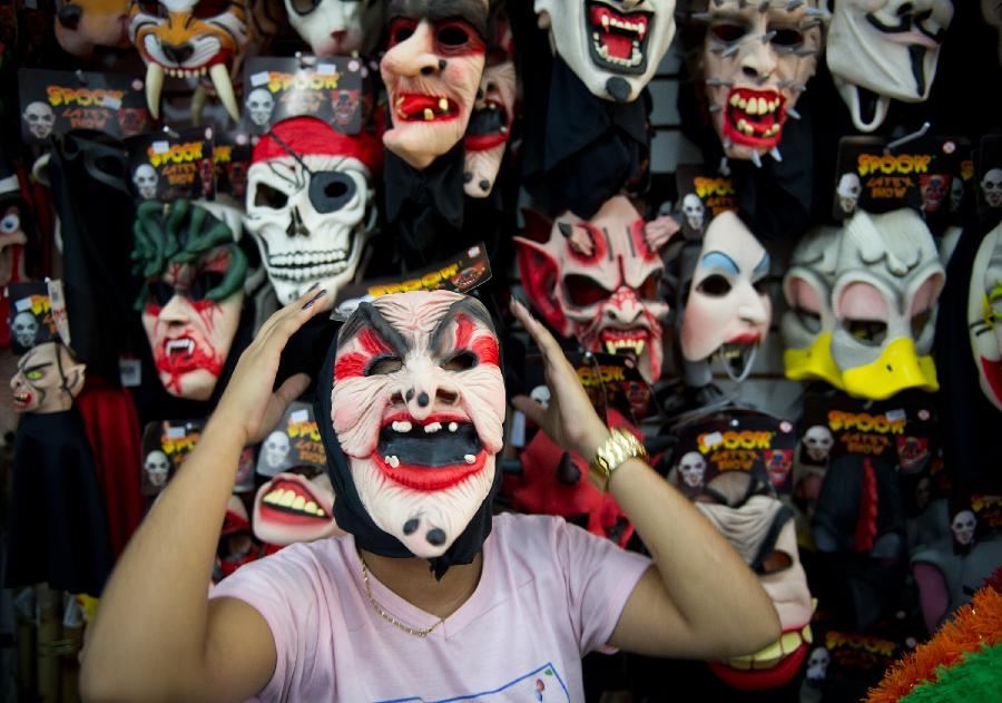 A woman tries on a carnival mask in a store in central Rio de Janeiro, Brazil, Jan. 18, 2013. Carnival-related products sell like hot cakes in Brazil, three weeks away from the annual Rio de Janeiro Carnival. (Xinhua/Weng Xinyang) 