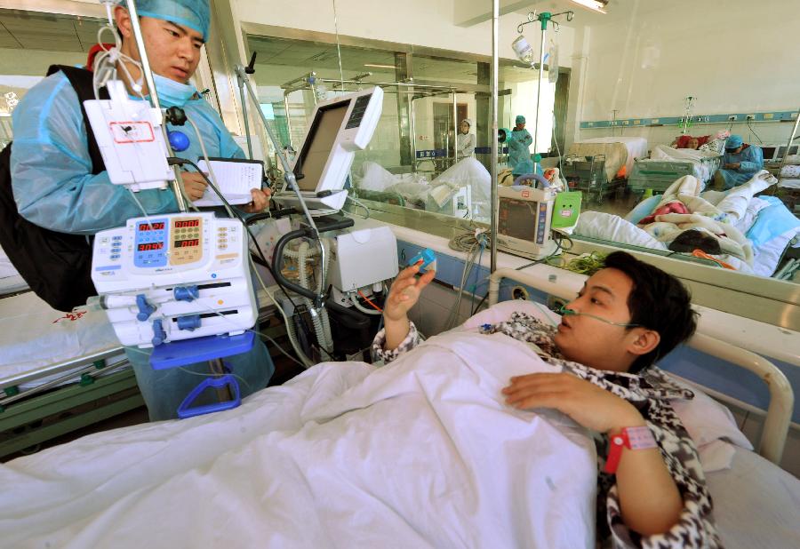 Sun Qisong (R), a survivor of a coal mine accident, receives interview in a hospital in southwest China's Guizhou Province, Jan. 19, 2013. The accident which occurred on Friday afternoon at the Jinjia Coal Mine under the Panjiang Investment Holding Group has left two people dead and 11 others trapped. Eighteen people were working underground at the time of the accident. Three of the five miners who have been lifted out of the mine were injured. (Xinhua/Yang Ying) 