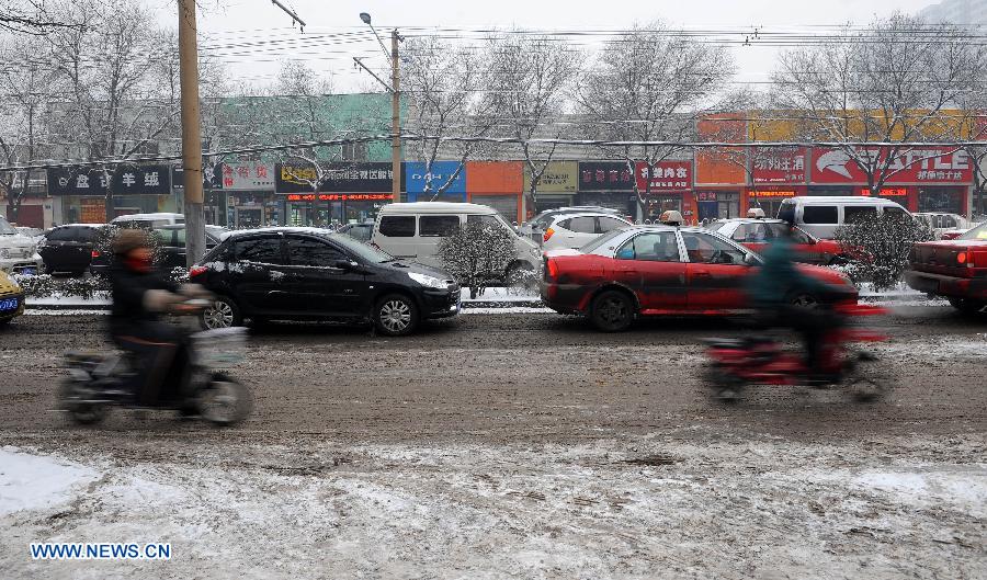 Vehicles run on a snow-covered road in Taiyuan City, capital of north China's Shanxi Province, Jan. 21, 2013. Snowfall hit Taiyuan at the weekend. (Xinhua/Fan Minda)