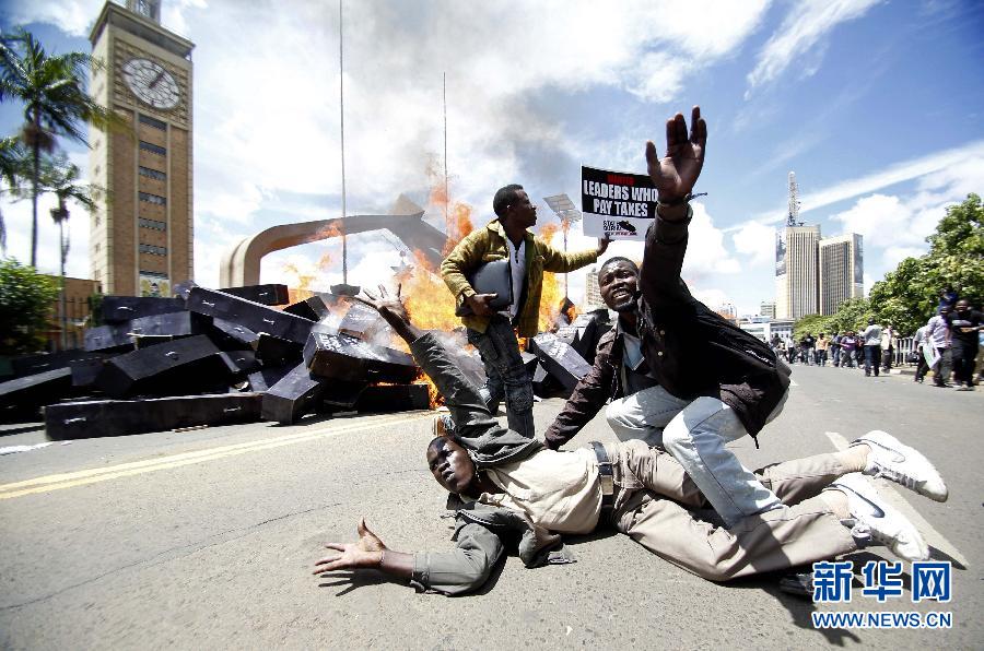 Demonstrators burn coffins to protest on a road in Nairobi, Kenya, Jan. 16, 2013. Demonstrators brought a total of 221 coffins to taunt the parliament members’ action of raising their bonus after the term, arranging body guards and enjoying state funeral treatment.(Xinhua/Reuters)
