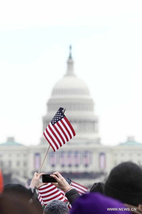 Spectators holding U.S. national flags watch the presidential inauguration ceremony on the West Front of the U.S. Capitol in Washington D.C., the United States, on Jan. 21, 2013. (Xinhua/Zhai Xi) 